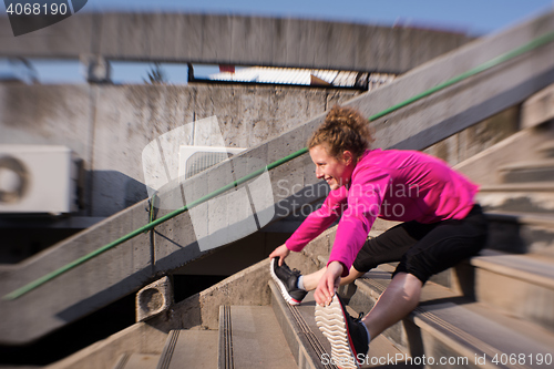 Image of woman  stretching before morning jogging