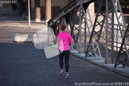 Image of sporty woman jogging on morning