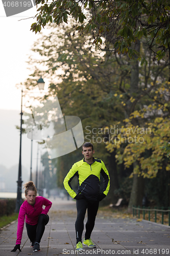 Image of couple warming up before jogging