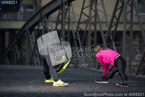 Image of couple warming up before jogging