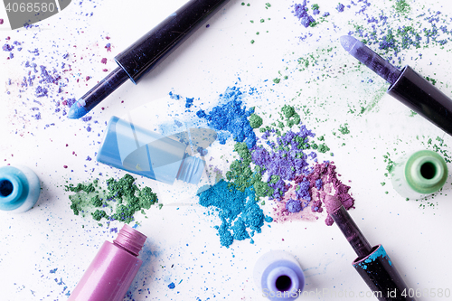 Image of Scattered multicolored eyeshadow with brushes and tube