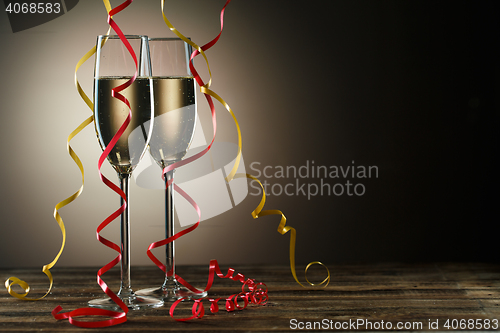 Image of Two champagne glasses on table decorated yellow and red ribbons