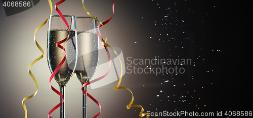 Image of Two glasses with sparkling champagne and decorative ribbons closeup