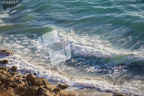 Image of Beautiful marine nature on sunny day, waves and stones