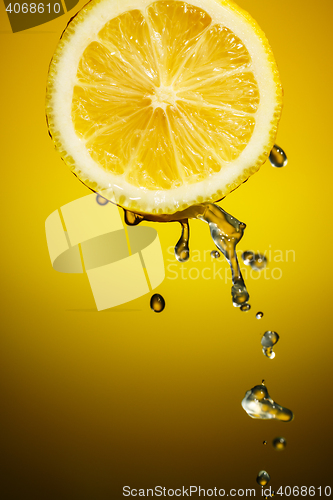 Image of One half of lemon with fresh water drops isolated on orange background