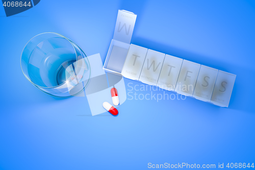 Image of reminder box for pills and a glass of water