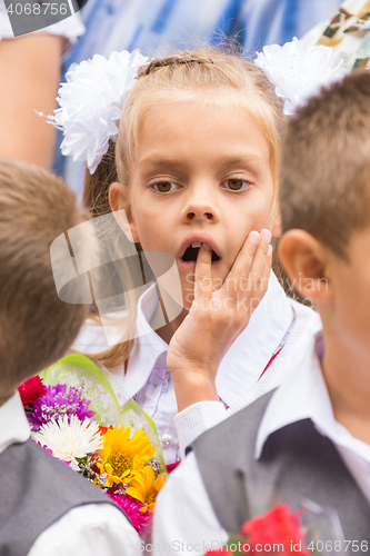 Image of First grader on the line of the first of September thinking stuck a finger in his mouth
