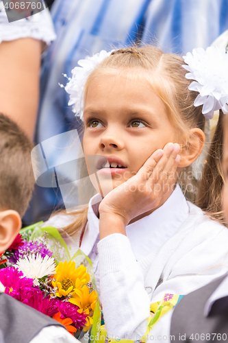 Image of First grader on the line of the first of September thinking looking up