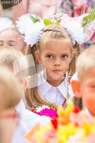 Image of Thoughtful first grader in the crowd of classmates on line the first of September