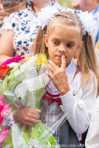 Image of First grader on the line of the first of September in thought looking down