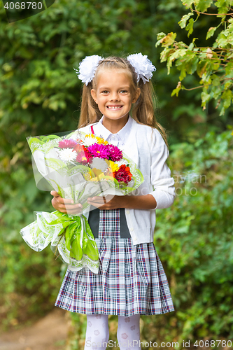 Image of First grader with a bouquet of flowers smiling happily