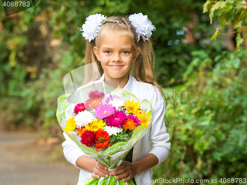 Image of Up portrait of a seven-year school girl with a bouquet of flowers