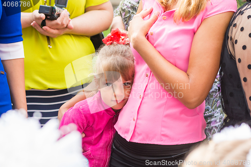 Image of Five-year girl standing in the crowd and clung to her mother