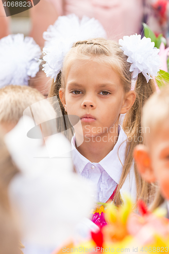 Image of First grader tired of classmates in the crowd at the first line of September