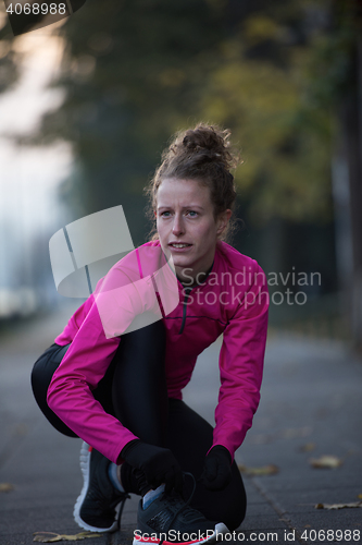 Image of woman  stretching before morning jogging