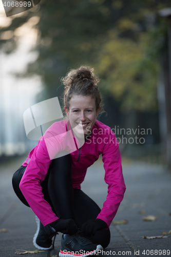 Image of woman  stretching before morning jogging