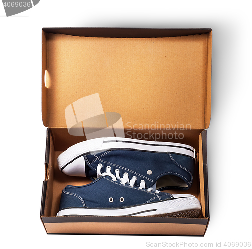 Image of Dark blue sports shoes inside cardboard box