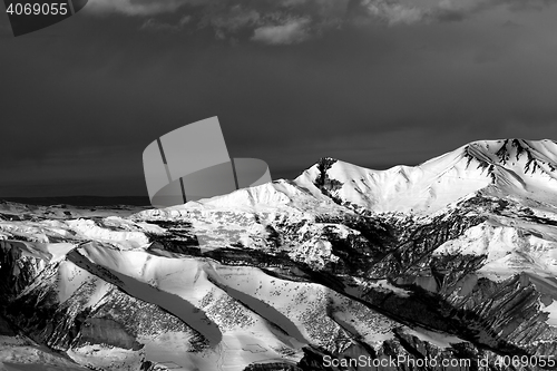Image of Black and white winter mountains at sun evening and dark clouds