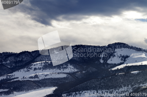 Image of Winter snow mountains and storm clouds at evening