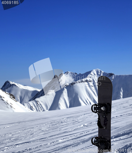 Image of Snowboard in snow on off-piste slope