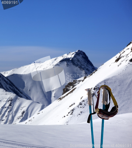 Image of Ski mask on ski poles and off-piste slope
