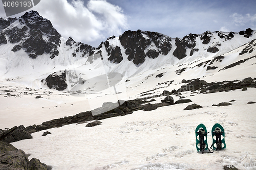 Image of Snowshoes in snow mountains in sun spring day