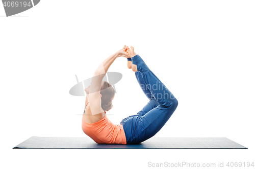 Image of Sporty fit woman practices yoga asana Dhanurasana