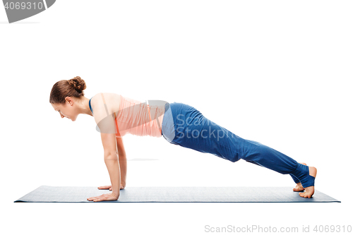 Image of Woman doing yoga asana Utthita chaturanga dandasana (or phalakasana)