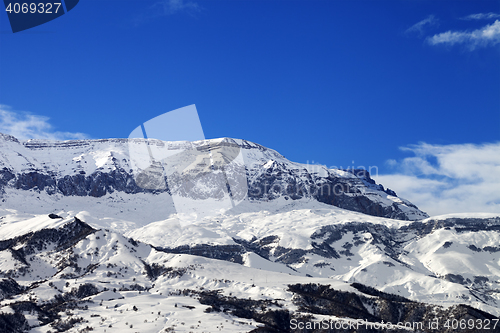 Image of Snowy mountains and blue sky at nice sun winter day