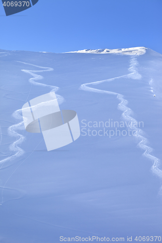 Image of Two traces from ski on off-piste slope in sun early morning