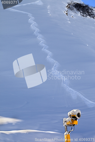 Image of Off-piste slope with trace from ski and snow gun in sun early mo