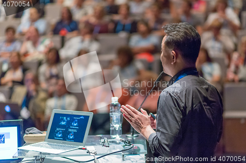 Image of Public speaker giving talk at Business Event.