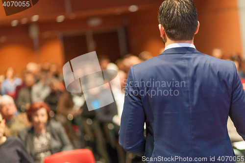 Image of Public speaker giving talk at Business Event.