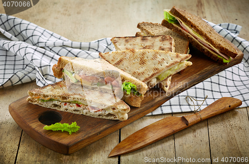Image of various triangle sandwiches on wooden board