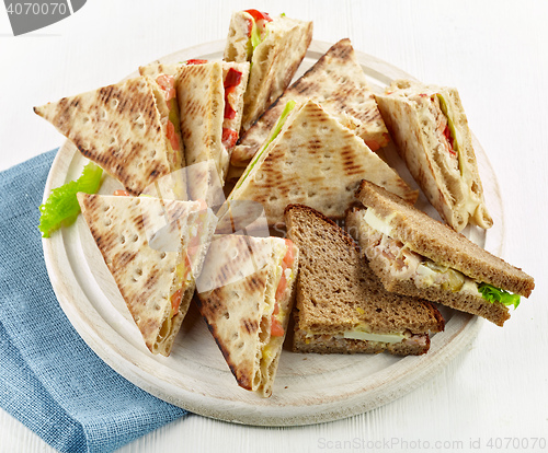 Image of various triangle sandwiches on wooden board