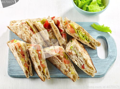 Image of various sandwiches on wooden cutting board