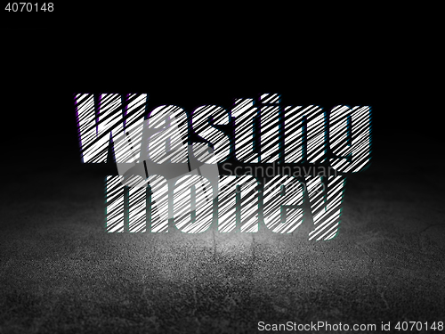 Image of Money concept: Wasting Money in grunge dark room