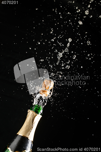 Image of Classic champagne bottle with cork exploding, alcoholic beverage