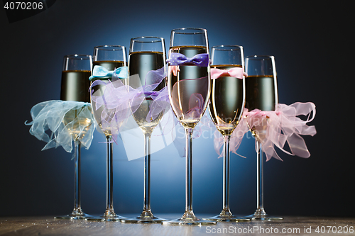 Image of Set of glasses with champagne in colored dress newlyweds