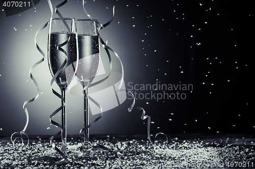Image of Stylish image of champagne glasses on dark background with snowfall