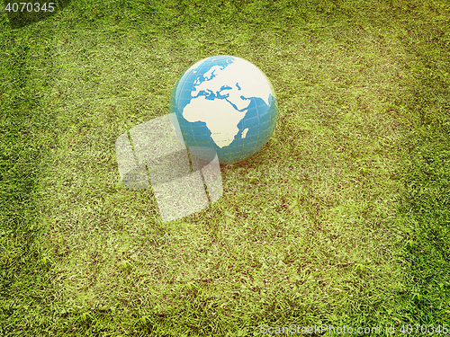 Image of earth on a green grass. 3D illustration. Vintage style.