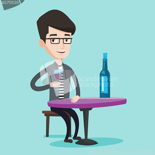 Image of Man drinking wine at restaurant.