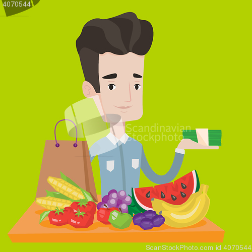 Image of Young man standing at the table with shopping bag