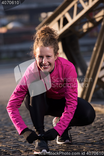Image of woman  stretching before morning jogging