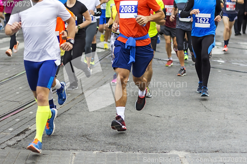 Image of Marathon runners race in city streets, blurred motion