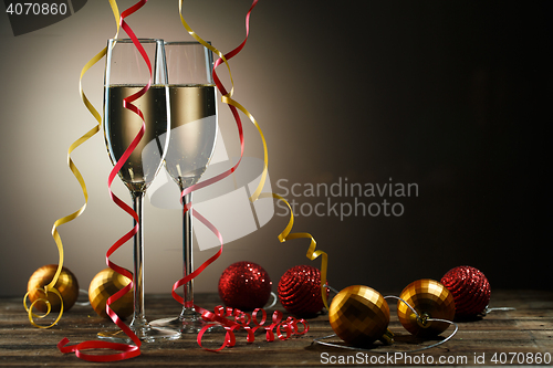Image of Two glasses with champagne and Christmas decoration ball