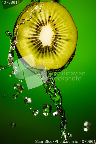 Image of Kiwi in water splash, isolated on green background