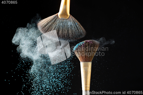 Image of Thick professional brush and loose powder particles scattered around