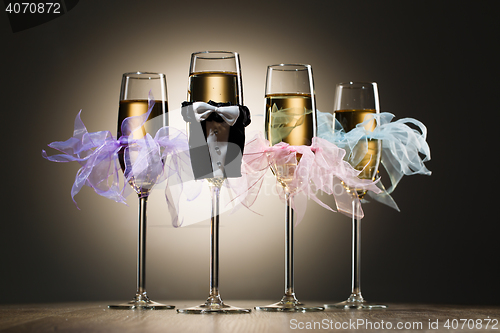 Image of Decorated glasses of champagne in gentleman costume and female tulle