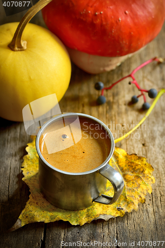 Image of Cup of coffee and pumpkin on wooden background